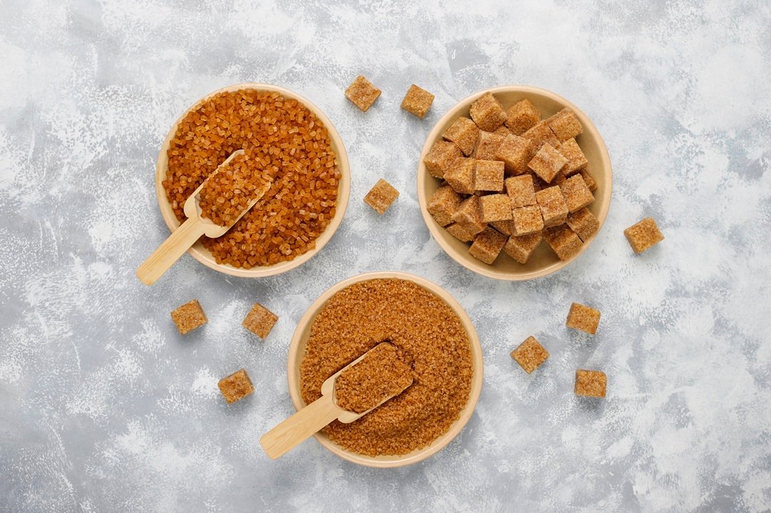 Various types of brown sugar on concrete background,top view